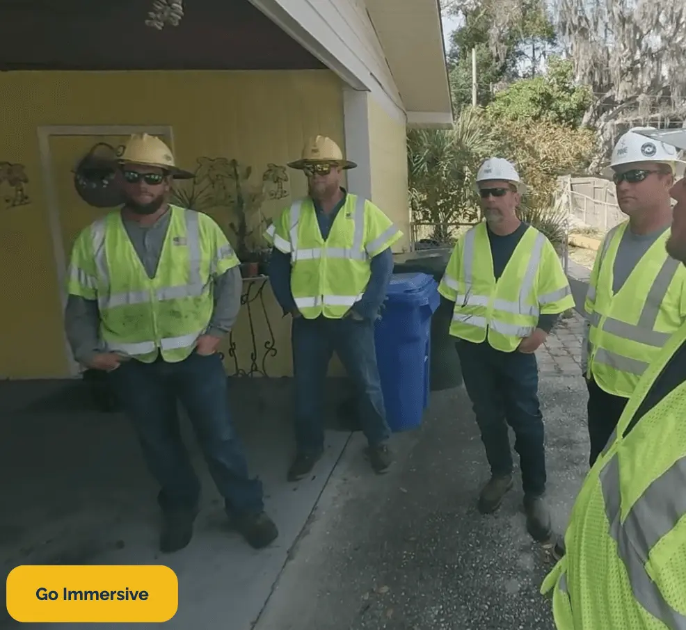 Electrical linemen standing around for a job hazard analysis